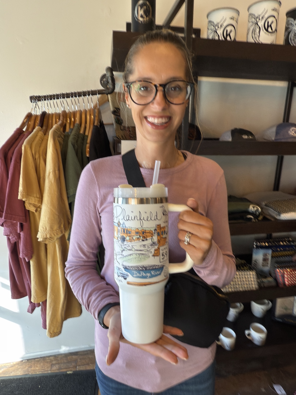 Ashley displaying the Plainfield tumbler inside Krema Coffee